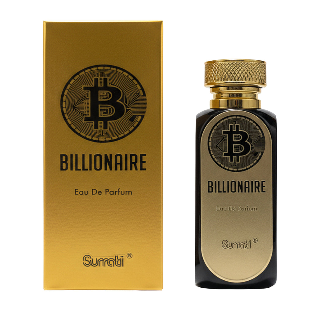 A bottle of Surati Billionaire Eau De Parfum next to its gold-colored packaging box, featuring a black Bitcoin logo and gold lettering on a white background.