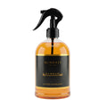 A clear glass spray bottle filled with amber-colored liquid, featuring a black trigger sprayer and a black label with gold text. The label reads 'Surrati' and 'Hamrah Luxury Fragrance'.