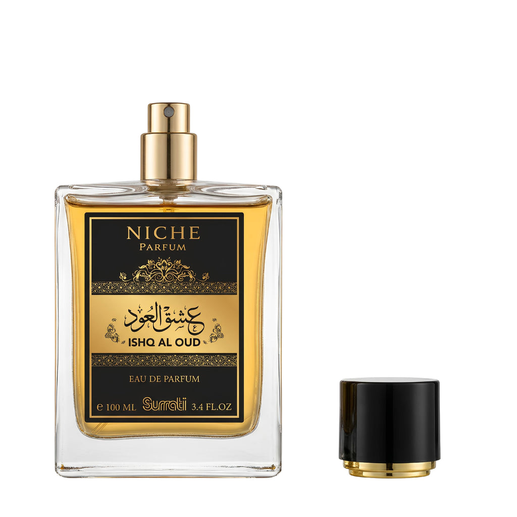 A clear rectangular perfume bottle filled with golden liquid, featuring a black and gold label that reads 'NICHE PARFUM' and 'ISHQ AL OUD'. The bottle is shown with its black cap removed and placed to the right, on a plain white background.