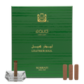 Green Surrati eau d'or box with incense sticks and a crystal holder on a white background