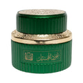 Green cosmetic jar with gold accents on a white background