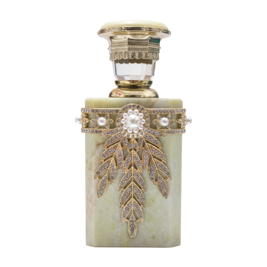 Decorative perfume bottle with gold accents and a white background