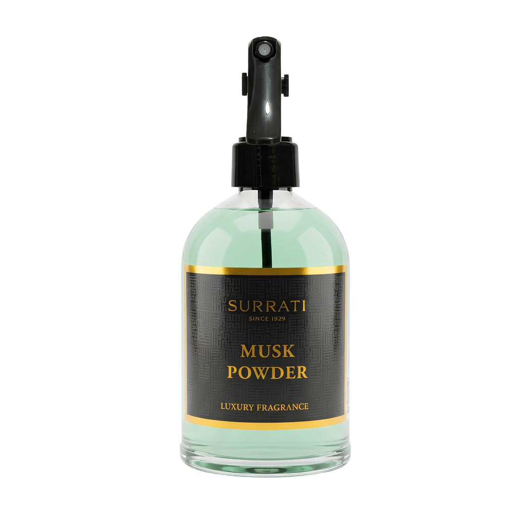 Surrati Musk Powder luxury fragrance in a clear glass bottle with pale green liquid, a black spray pump, and a black label with gold lettering, shown on a white background.