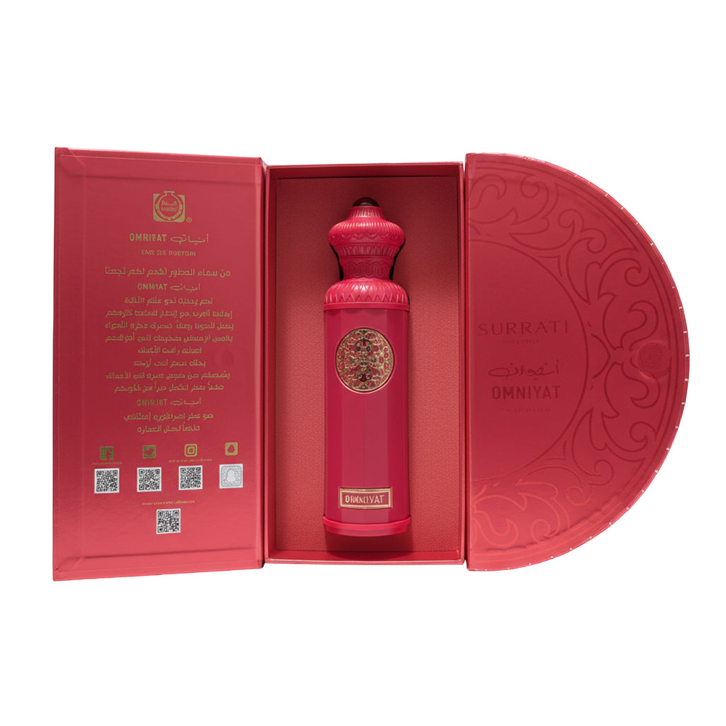 Red perfume bottle with intricate design in an open box on a white background