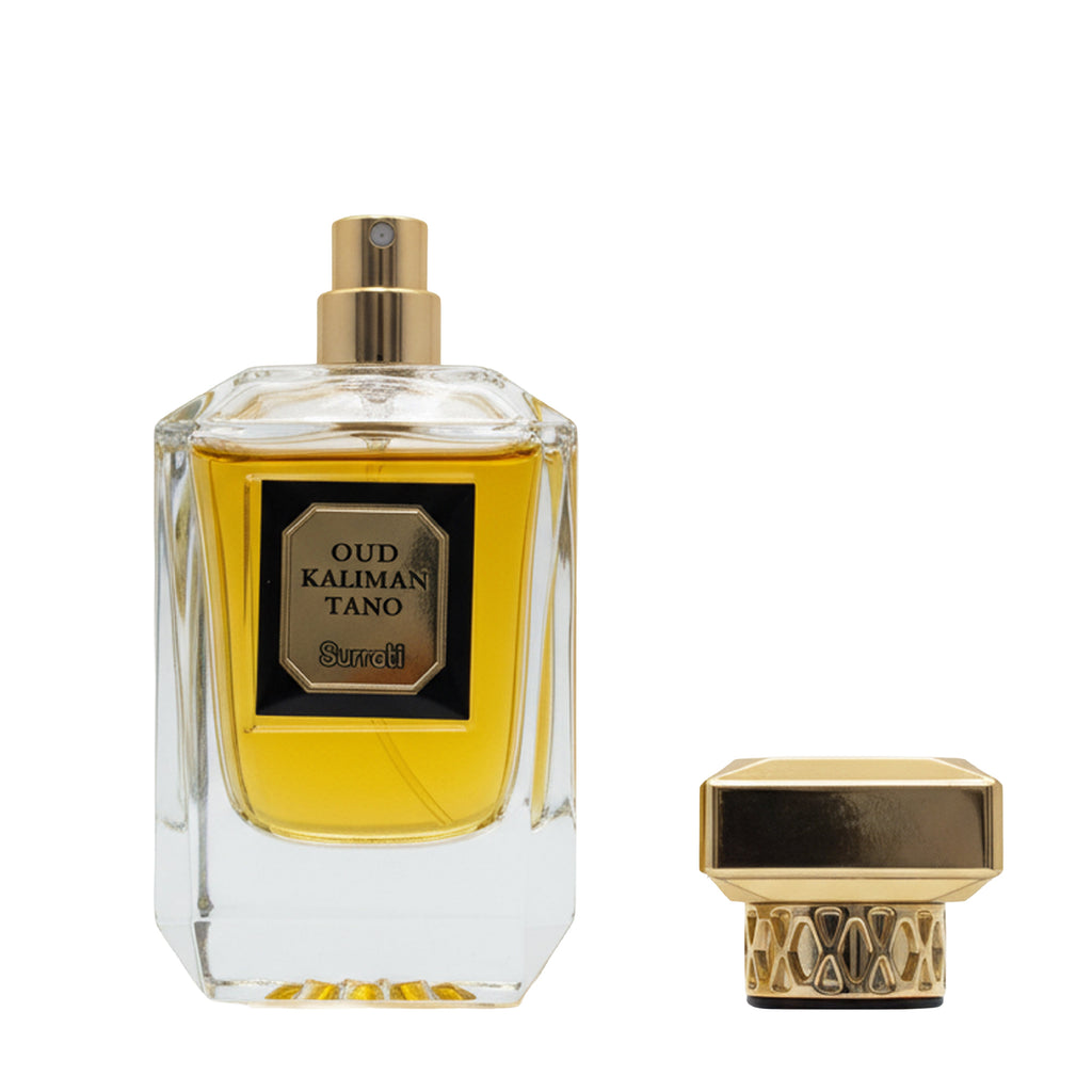 A clear glass perfume bottle filled with golden-yellow liquid, featuring a gold spray top and a black-and-gold label that reads 'OUD KALIMAN TANO' with the brand 'Souri' below. A matching gold cap is shown beside the bottle on a plain white background.