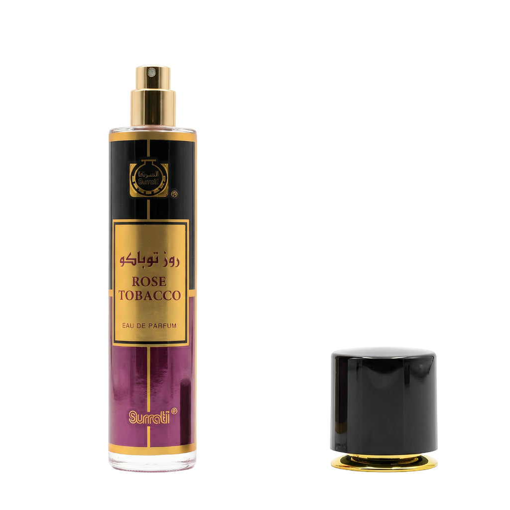 A bottle of Surati Rose Tobacco Eau de Parfum with a gold and black label, shown next to its detached black cap with a gold base on a white background.