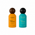 Two Surrati perfume bottles on a white background, one in orange with a dark brown wooden cap and labeled 'Night Memories', and one in teal with a black wooden cap and labeled 'Rose Imperial'.