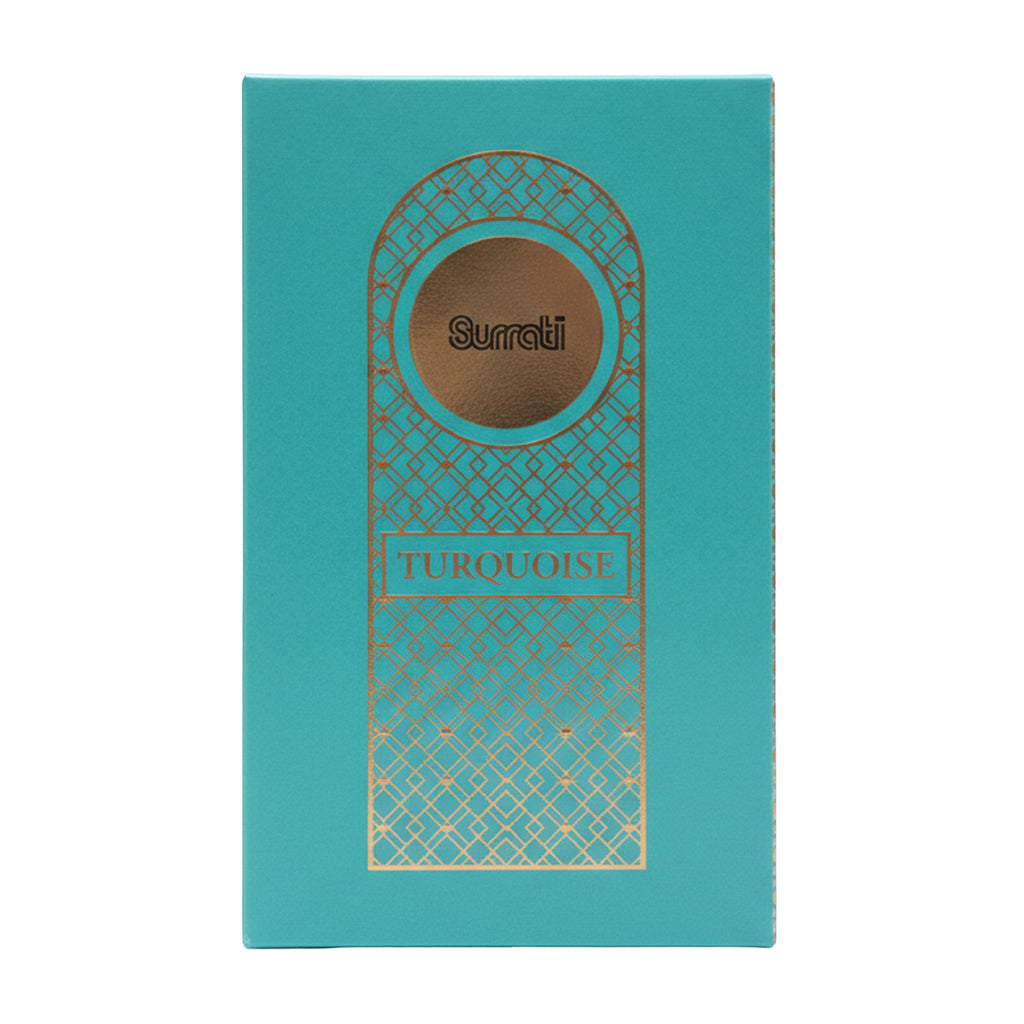 A rectangular turquoise cosmetic box with gold geometric line art and a central oval window showing the shade name 'Surati' and color 'Turquoise'.