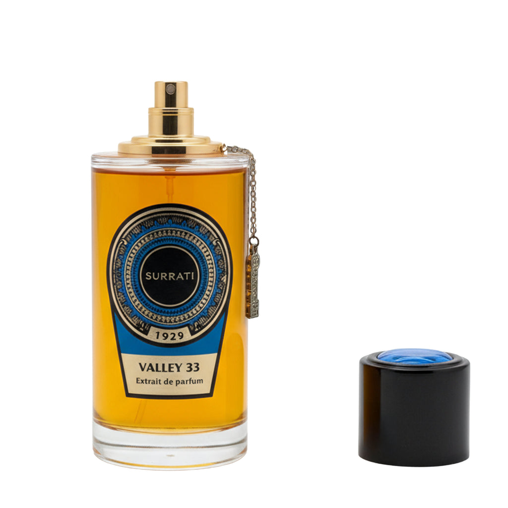 Surrati Valley 33 Extrait de Parfum bottle with a gold spray top and a blue/black label, shown next to its black cap with a blue top on a white background.